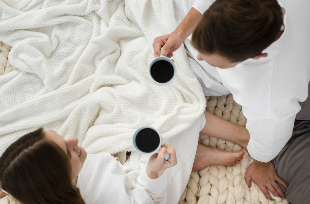 top-view-couple-bathrobes-holding-coffee-cups.jpg
