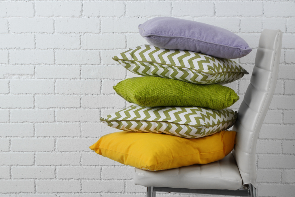 colorful-pillows-chair-white-bricks-wall-background.jpg