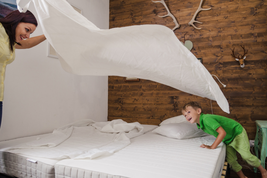 woman-playing-with-child-while-making-bed.jpg